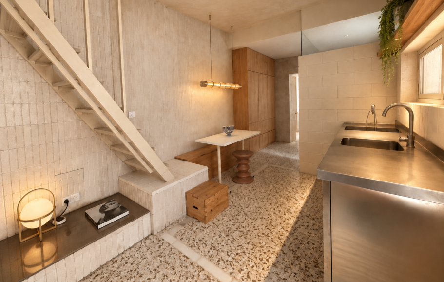 INTERIORISMO MARBELLA Sala moderna con un sofá marrón, mesa de madera y una chimenea minimalista.