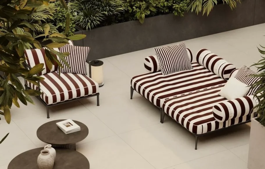 Salón moderno con sillas de madera, mesa de centro y estantería, con luz natural abundante.