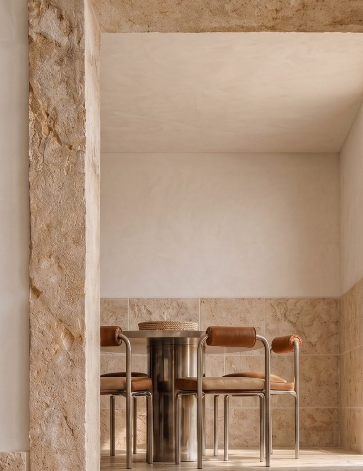 INTERIORISMO BENALMADENA Mesa de madera con sillas, decoración minimalista y luz suave en un espacio moderno.