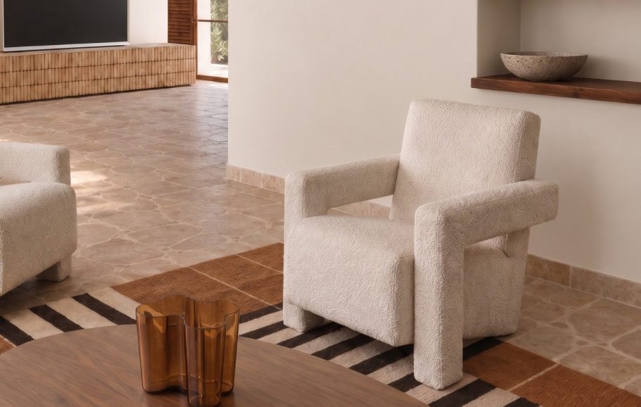 INTERIORISMO FUENGIROLA Salón moderno con sillas de madera, mesa de centro y estantería, con luz natural abundante.