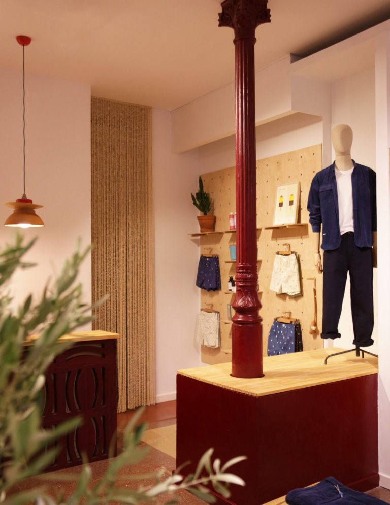 INTERIORISMO FUENGIROLA Salón moderno con sillas de madera, mesa de centro y estantería, con luz natural abundante.