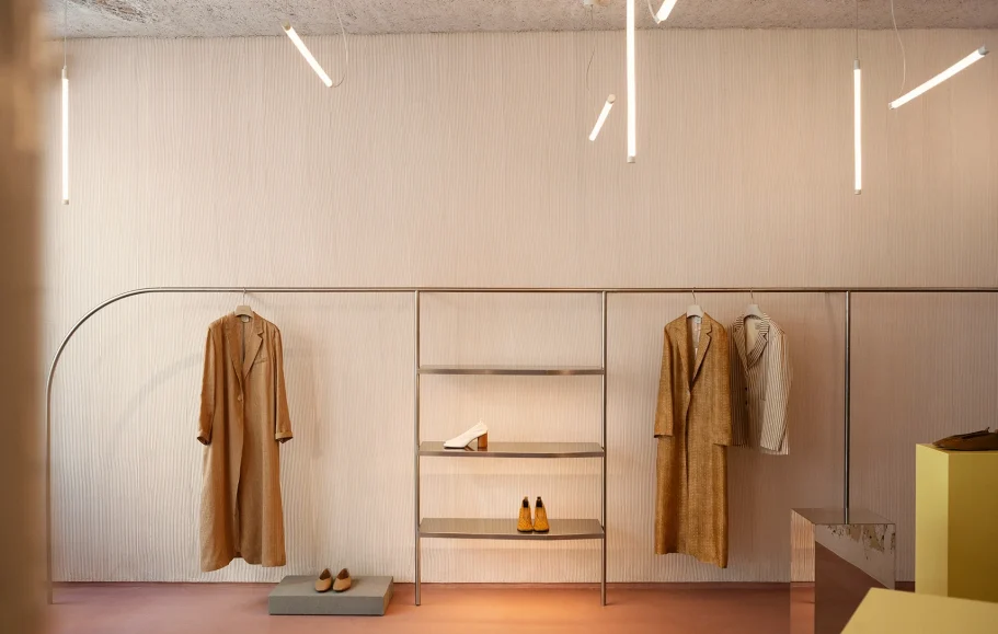 INTERIORISMO FUENGIROLA Salón moderno con sillas de madera, mesa de centro y estantería, con luz natural abundante.
