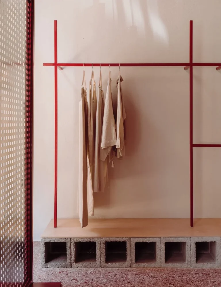 INTERIORISMO FUENGIROLA Salón moderno con sillas de madera, mesa de centro y estantería, con luz natural abundante.