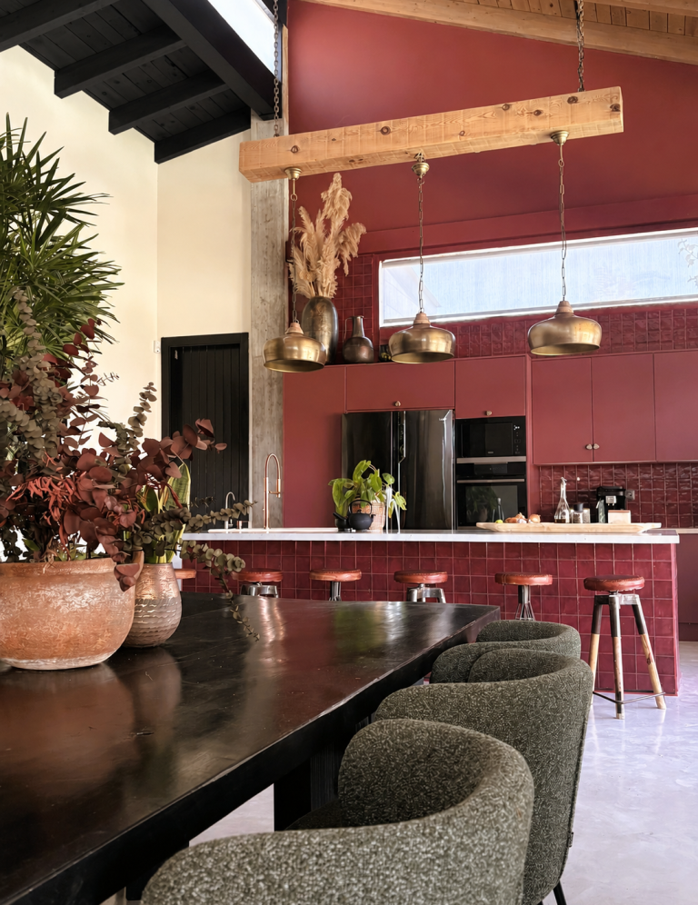 INTERIORISMO FUENGIROLA Salón moderno con sillas de madera, mesa de centro y estantería, con luz natural abundante.